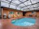 Refreshing pool with patio furniture under screened enclosure at 1415 Park Ave, Tavares, FL 32778