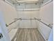 Walk-in closet with rod and shelf storage solutions, plus new gray wood-look flooring at 149 Royal Palm Dr, Leesburg, FL 34748