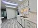 Functional kitchen with white cabinets, stainless steel sink, and updated flooring for efficient living at 149 Royal Palm Dr, Leesburg, FL 34748