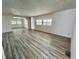 Spacious living room with light gray flooring, white walls, and natural light from window shutters at 149 Royal Palm Dr, Leesburg, FL 34748