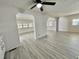 Spacious open concept living area with modern gray flooring, perfect for entertaining at 149 Royal Palm Dr, Leesburg, FL 34748