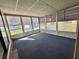 Bright sun room featuring large windows, neutral wall paneling, and carpet flooring provides relaxation and sunlight at 149 Royal Palm Dr, Leesburg, FL 34748
