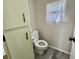 Cozy toilet room with tile flooring, a small window, and a large cabinet for storage at 149 Royal Palm Dr, Leesburg, FL 34748