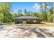 Rear view of a single-story home featuring sliding glass doors and a spacious yard at 15323 Sw 25Th Pl, Ocala, FL 34482