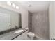 Modern bathroom featuring granite counters, a walk-in shower, and neutral gray tiling at 15323 Sw 25Th Pl, Ocala, FL 34482