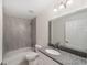 Modern bathroom featuring granite counters, a tub, and neutral gray tiling at 15323 Sw 25Th Pl, Ocala, FL 34482
