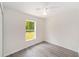 Well-lit bedroom with wood-look floors, a ceiling fan, and a view of the backyard at 15323 Sw 25Th Pl, Ocala, FL 34482