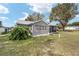 Exterior backyard view of the house, highlighting the enclosed patio and landscaping at 1613 Cherry Hill Rd, The Villages, FL 32159