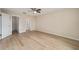 Bedroom with ceiling fan, wood-look floors and doorways to bathroom and walk-in closet at 1613 Cherry Hill Rd, The Villages, FL 32159