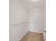 This is a walk-in closet with wire shelving and light, wood-look flooring at 1613 Cherry Hill Rd, The Villages, FL 32159