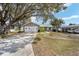 Well-maintained home featuring a two-car garage, mature trees, and inviting curb appeal at 1613 Cherry Hill Rd, The Villages, FL 32159
