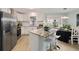Bright kitchen featuring stainless steel appliances, an island with seating, and an adjacent dining area at 1613 Cherry Hill Rd, The Villages, FL 32159