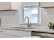 Kitchen featuring white subway tile, a stainless steel sink with a gold faucet, and granite countertops at 1613 Cherry Hill Rd, The Villages, FL 32159
