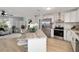 An open-concept kitchen with stainless steel appliances, marble countertops, and a breakfast bar with seating at 1613 Cherry Hill Rd, The Villages, FL 32159