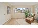 Bright living room with natural light, wood floors, wicker furniture, and a fluffy white rug at 1613 Cherry Hill Rd, The Villages, FL 32159