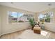 Sunlit living room with natural textures, a cozy chair set, wood floors, and expansive windows at 1613 Cherry Hill Rd, The Villages, FL 32159