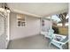 Enclosed patio featuring two Adirondack chairs, gray siding, concrete flooring, and an exterior view at 1613 Cherry Hill Rd, The Villages, FL 32159