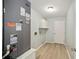 Well-lit utility room featuring wood floors, a utility sink, a modern light fixture, and a closed door at 1613 Cherry Hill Rd, The Villages, FL 32159