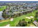 An elevated aerial view of a golf course community, showcasing sand traps and mature landscaping at 16814 Se 80Th Bellavista Cir, The Villages, FL 32162