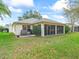Charming home exterior features a screened lanai and views of a lush lawn and garden at 16814 Se 80Th Bellavista Cir, The Villages, FL 32162