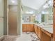Bright bathroom with a double sink vanity, walk-in shower, and neutral tile flooring at 16814 Se 80Th Bellavista Cir, The Villages, FL 32162