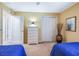 Bedroom showcases twin beds, closet, and neutral carpet, with a dresser and decor at 16814 Se 80Th Bellavista Cir, The Villages, FL 32162