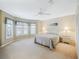 Spacious bedroom features a large window, ceiling fan, neutral walls, and carpeted floors at 16814 Se 80Th Bellavista Cir, The Villages, FL 32162