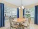 Bright dining area with a round table and a large window with blue curtains at 16814 Se 80Th Bellavista Cir, The Villages, FL 32162