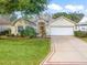 Inviting front exterior featuring a well-manicured lawn and a two-car garage at 16814 Se 80Th Bellavista Cir, The Villages, FL 32162