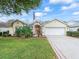 Charming front exterior of the home featuring a two-car garage and lush landscaping at 16814 Se 80Th Bellavista Cir, The Villages, FL 32162