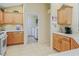 Kitchen features wood cabinets, tile floor and doorway into the laundry room at 16814 Se 80Th Bellavista Cir, The Villages, FL 32162