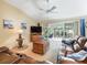 Bright living room featuring a leather sofa, TV, and sliding doors to a screened patio overlooking the golf course at 16814 Se 80Th Bellavista Cir, The Villages, FL 32162