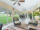Inviting sunroom with ceiling fans and scenic views of the landscaped backyard and golf course at 16814 Se 80Th Bellavista Cir, The Villages, FL 32162