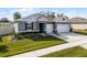 Two-car garage home with gray siding, red accents and landscaping at 17938 Hither Hills Cir, Winter Garden, FL 34787