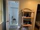 Bathroom with a walk-in shower, seat, a white toilet, and a wicker shelf at 188 Hibiscus Way, Leesburg, FL 34748
