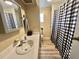 Bathroom featuring a sink, mirror, and a tub with a black and white curtain at 188 Hibiscus Way, Leesburg, FL 34748