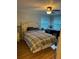 Bedroom featuring a ceiling fan, windows, and a bed with a plaid cover at 188 Hibiscus Way, Leesburg, FL 34748