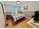 Bedroom features a bed, side tables, a window, and a painting at 188 Hibiscus Way, Leesburg, FL 34748