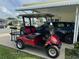 Convenient covered parking carport with a golf cart and vehicle, providing protection from the elements at 188 Hibiscus Way, Leesburg, FL 34748