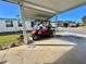 Carport featuring ample space with the golf cart providing a shaded area for parking and storage at 188 Hibiscus Way, Leesburg, FL 34748