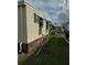 Home exterior featuring vinyl siding and green shutters with a well-maintained lawn at 188 Hibiscus Way, Leesburg, FL 34748