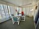 Enclosed porch with seating and plenty of natural light at 188 Hibiscus Way, Leesburg, FL 34748