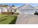 White house with two-car garage and well-manicured lawn at 2507 Caribe Dr, The Villages, FL 32162