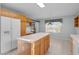 Eat-in kitchen with an island, tiled floors, and sliding glass doors to a lanai at 2507 Caribe Dr, The Villages, FL 32162