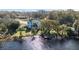 Aerial view of a waterfront home with lush landscaping and dock at 26845 County Road 448A, Mount Dora, FL 32757