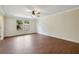 Spacious bedroom with wood floors, ceiling fan, and large windows at 30138 Losino Cv, Mount Dora, FL 32757