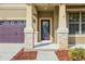 Front entry with stone columns and a decorative door at 30138 Losino Cv, Mount Dora, FL 32757