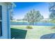 View of the serene lake from the lush backyard, perfect for outdoor relaxation and enjoyment at 3315 Woodridge Dr, The Villages, FL 32162