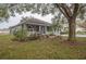 Charming home exterior with mature trees and manicured landscaping at 4343 Hammersmith Dr, Clermont, FL 34711