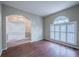 Bright living room featuring wood floors, an archway, and a window with classic white shutters at 4343 Hammersmith Dr, Clermont, FL 34711